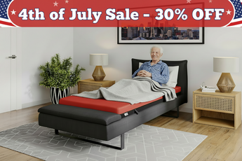 Man lying on a black and red bed with a 4th of July Sale banner above.